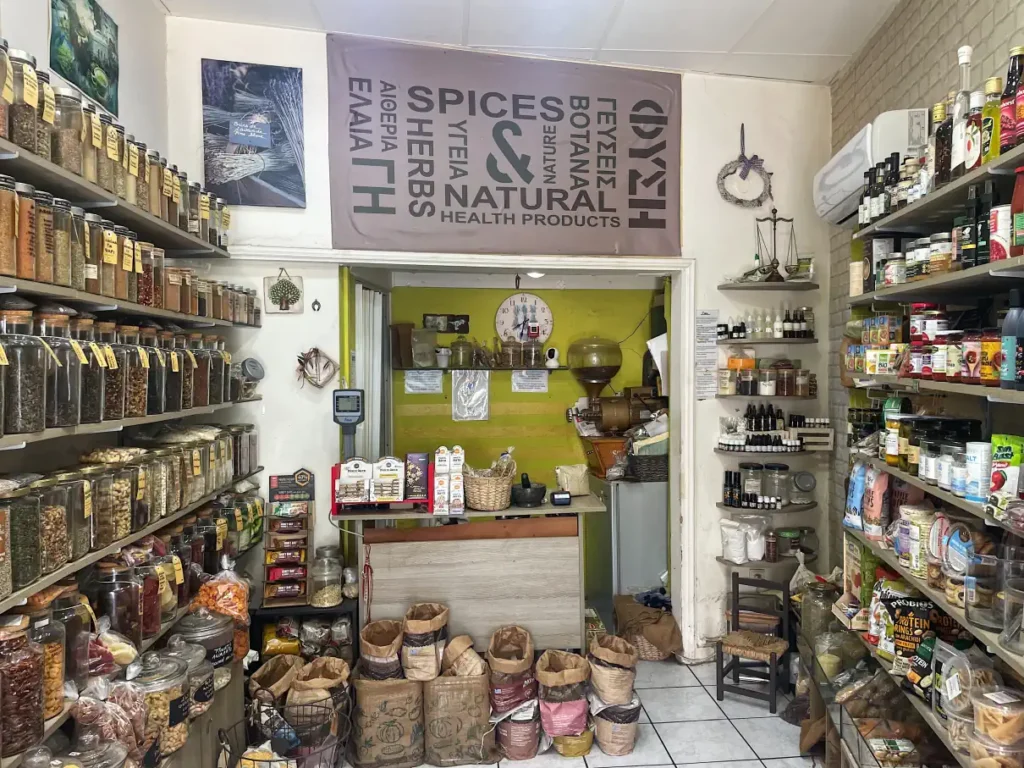 Interior of a traditional Corfu spice shop with shelves of herbs, spices, natural health products, paper sacks, and local goods.